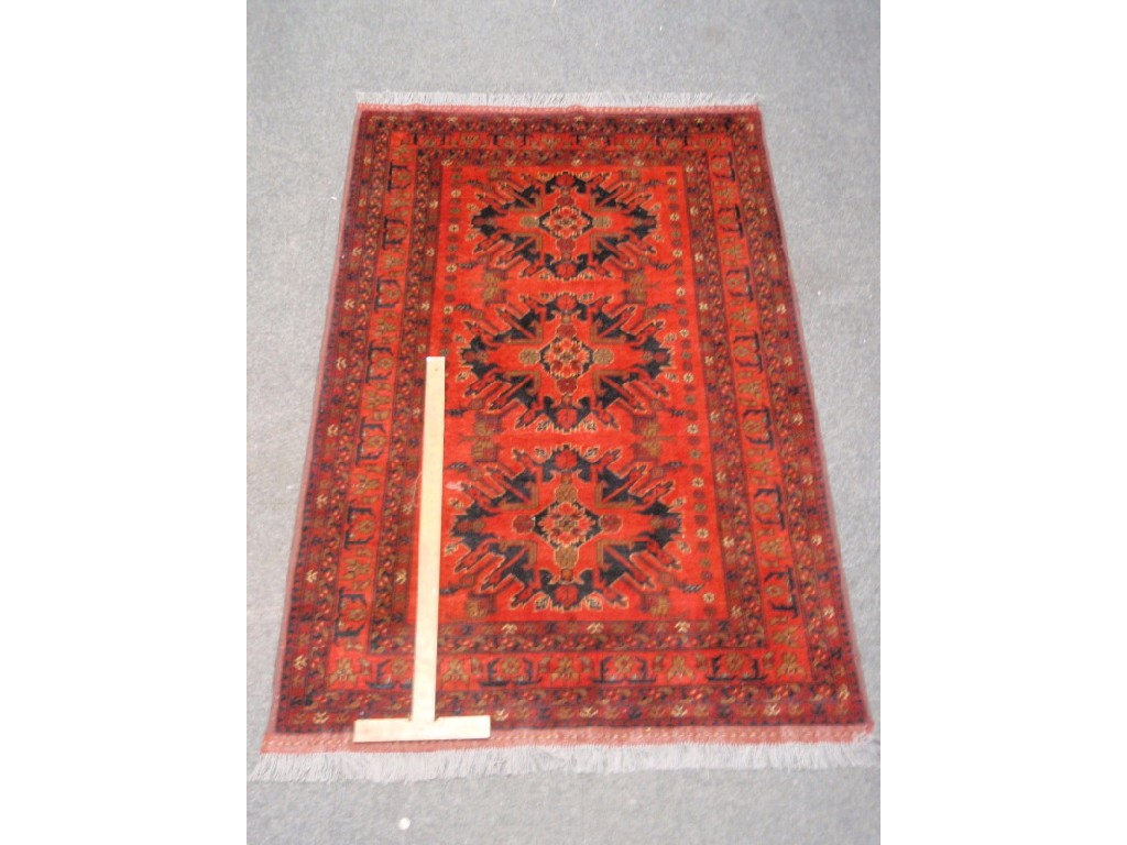 Appraisal: A red and orange ground tri-medallion rug cm x cm