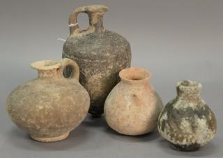 Appraisal: Four ancient stone and clay urns including a terracotta handled