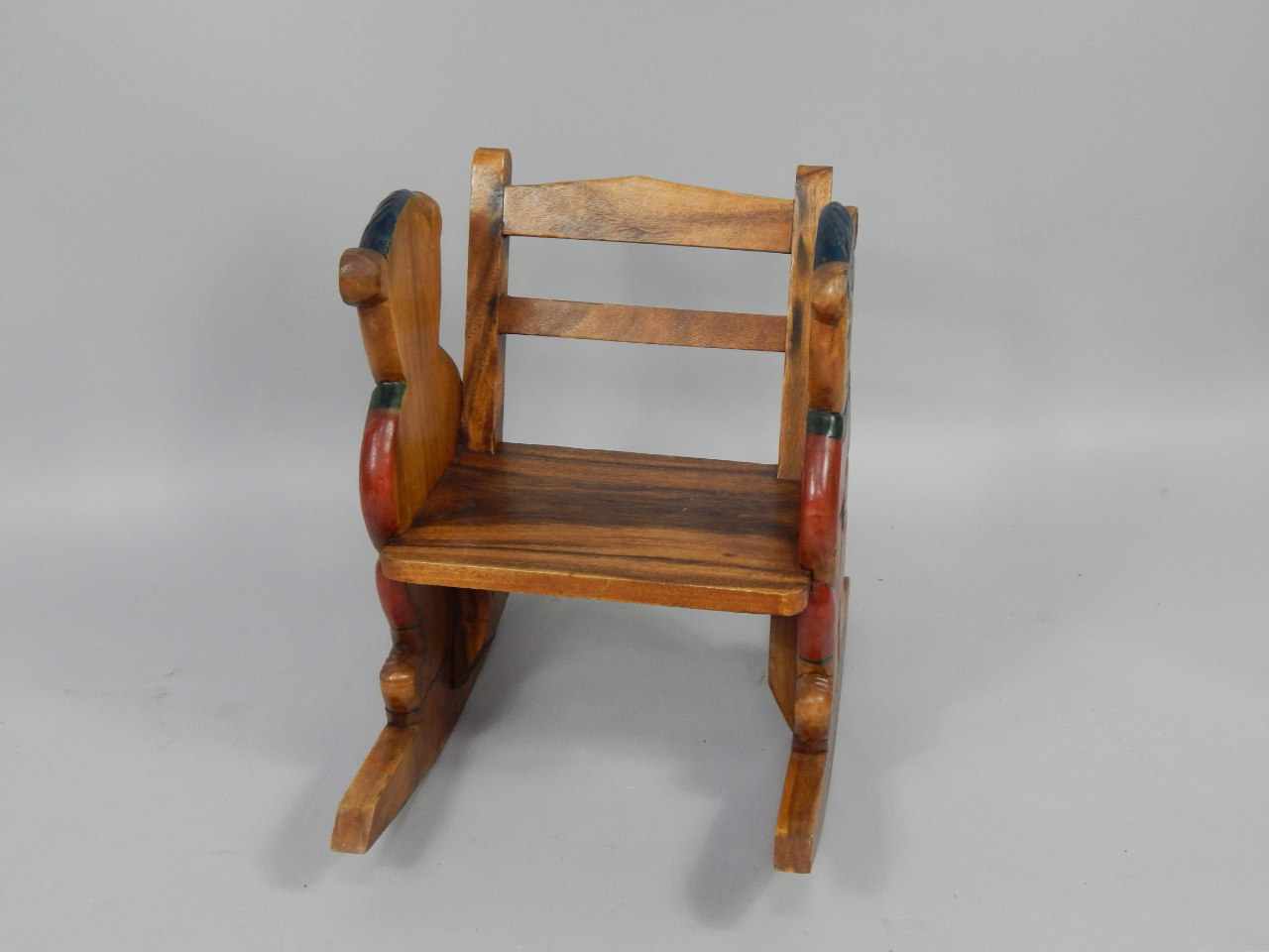 Appraisal: A child's hardwood rocking chair carved and painted to the