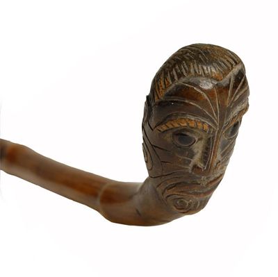 Appraisal: A Maori bamboo cane the handle carved with a moko