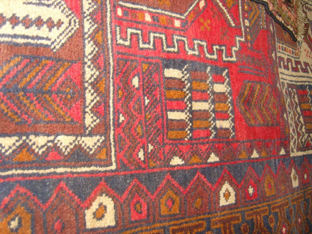 Appraisal: An eastern wool rug with geometric decoration in red blue