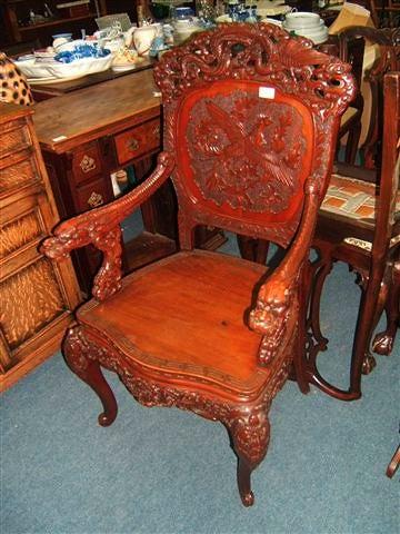 Appraisal: An Oriental hardwood open armchair decorated overall with dragons the