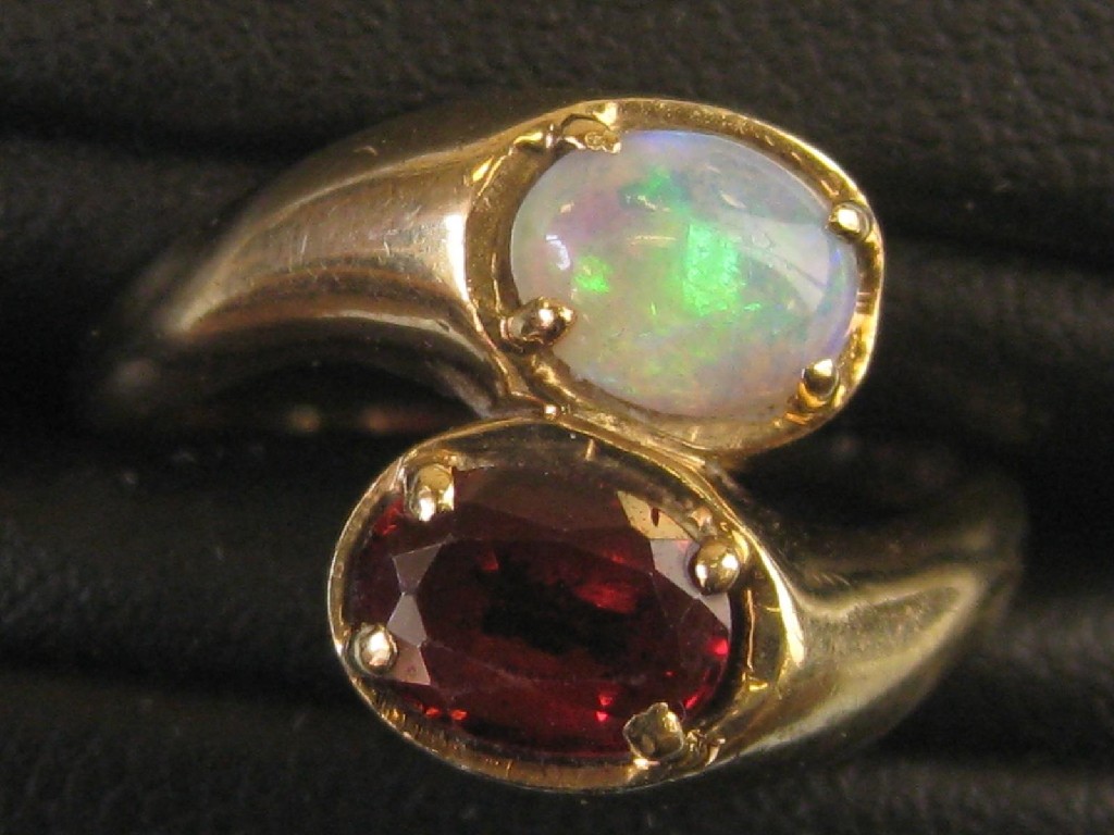 Appraisal: An Opal and Garnet Crossover Ring the opal cabochon and