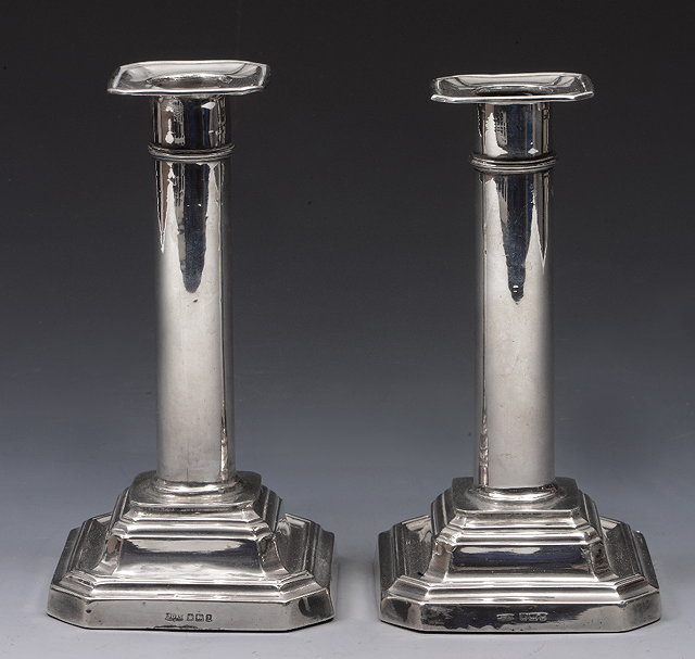 Appraisal: A PAIR OF SILVER DWARF CANDLESTICKS with square stepped bases