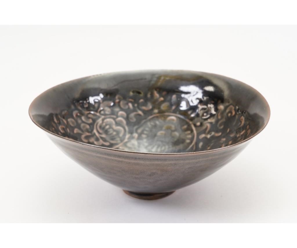 Appraisal: Chinese Yaozhou iron black glazed tea bowl with molded floral