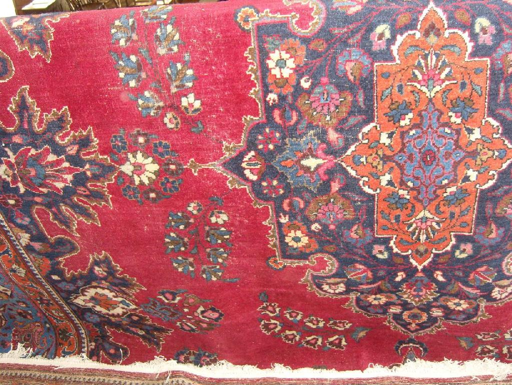 Appraisal: A wool carpet with red field and central blue medallion