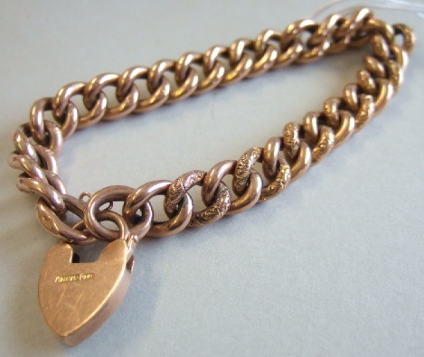 Appraisal: A gold decorated and plain curb link bracelet on a