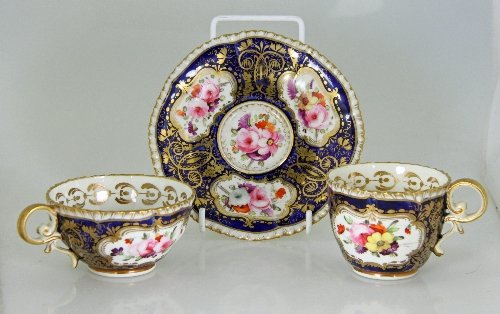 Appraisal: A Coalport trio finely painted reserves of summer flowers within