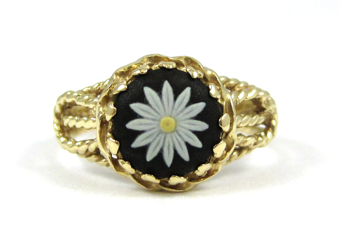 Appraisal: FOURTEEN KARAT GOLD FLOWER MOTIF RING featuring a mm round