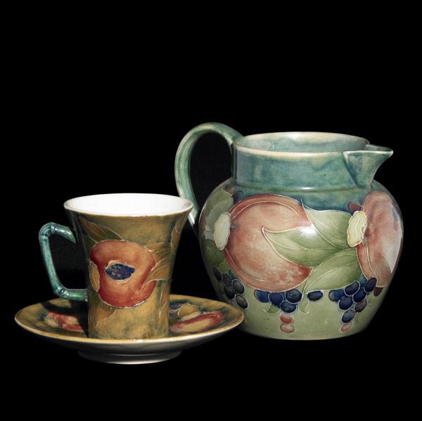 Appraisal: MOORCROFT Milk pitcher with cup and saucer in the Pomegranate