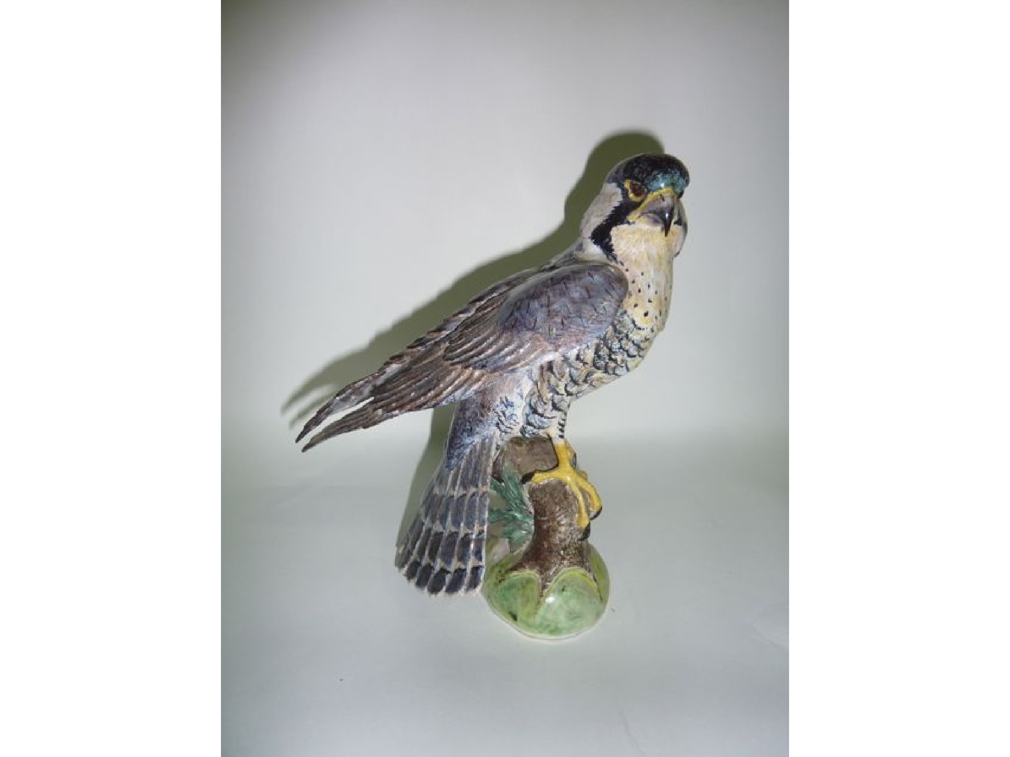 Appraisal: A naturalistically modelled figure of a bird of prey perched