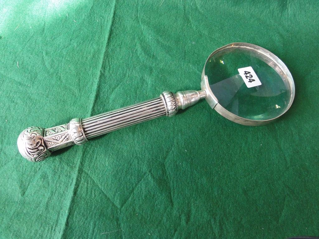 Appraisal: An outsized magnifying glass with white metal turned and fluted