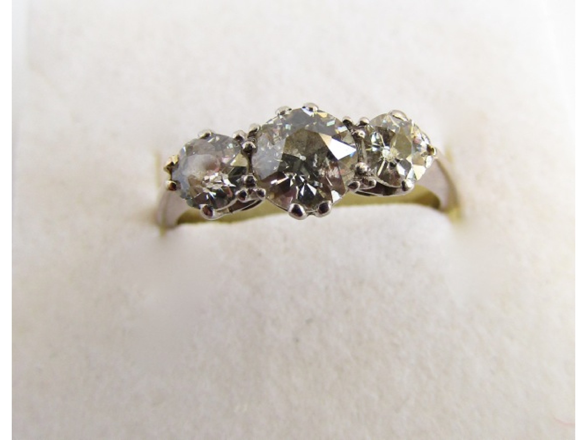 Appraisal: A three-stone diamond ring centred with a round brilliant-cut diamond