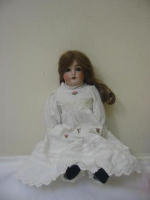 Appraisal: A German bisque shoulder head girl doll with brown glass