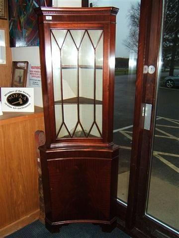 Appraisal: A mahogany corner cupboard with single glazed door above and