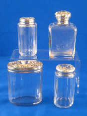 Appraisal: Four toilet bottles two with hallmarked silver lids two with