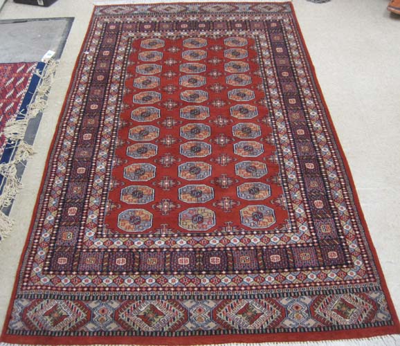 Appraisal: RED FIELD BOKHARA AREA RUG Indo-Turkoman hand knotted ' x