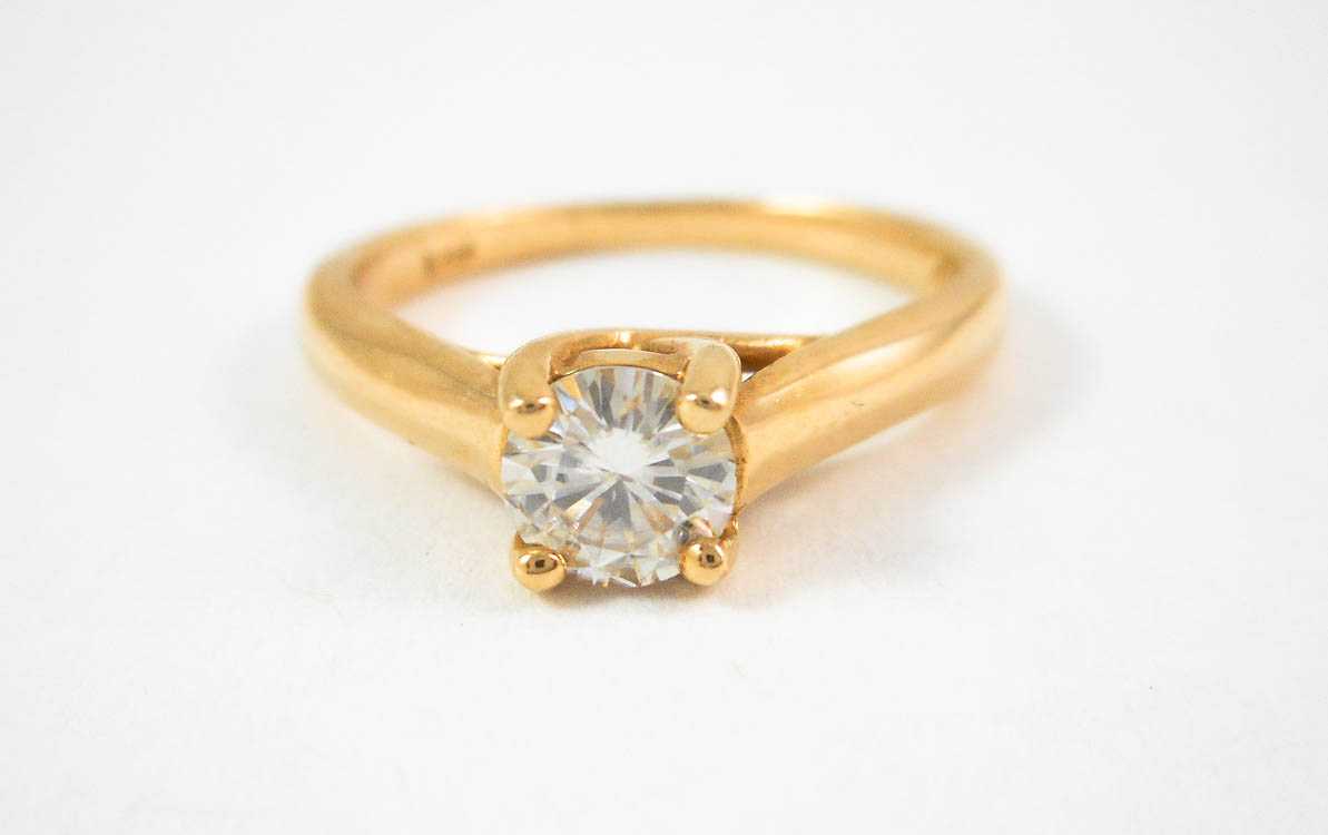 Appraisal: MOISSANITE AND FOURTEEN KARAT GOLD SOLITAIRE RING with four yellow