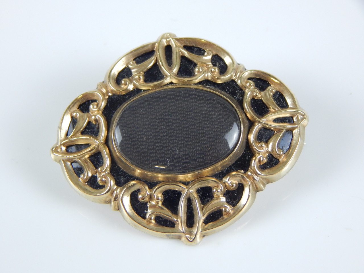 Appraisal: A memorial brooch with hair filled insert gold and enamel