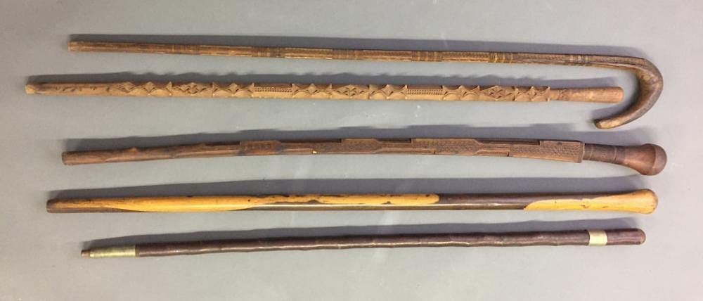 Appraisal: Three Chipped Carved Walking Sticks Three chipped carved walking sticks