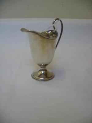 Appraisal: A CREAM JUG of helmet form with moulded rim scroll