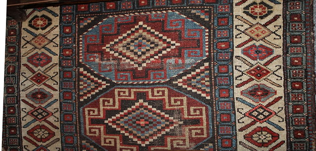 Appraisal: A KAZAK RUG with central geometric medallions within a wide