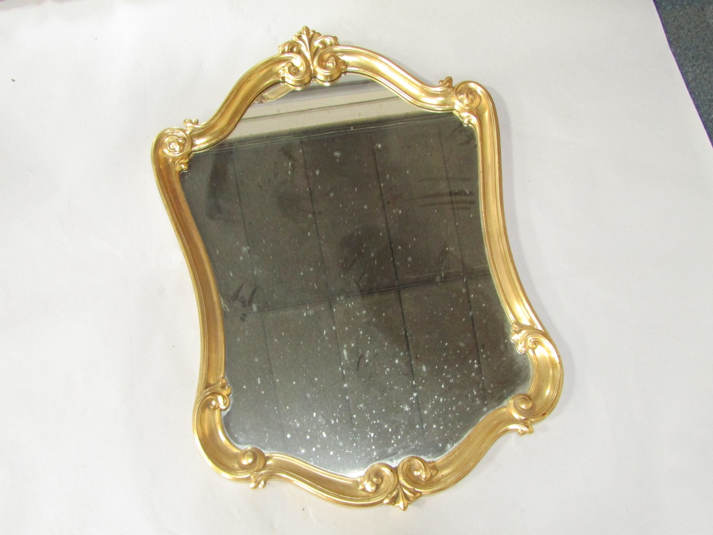 Appraisal: A Rococo style gilt plaster wall mirror with shell and