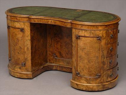 Appraisal: VICTORIAN FIGURAL WALNUT KIDNEY-SHAPE DESK The tooled green leather top