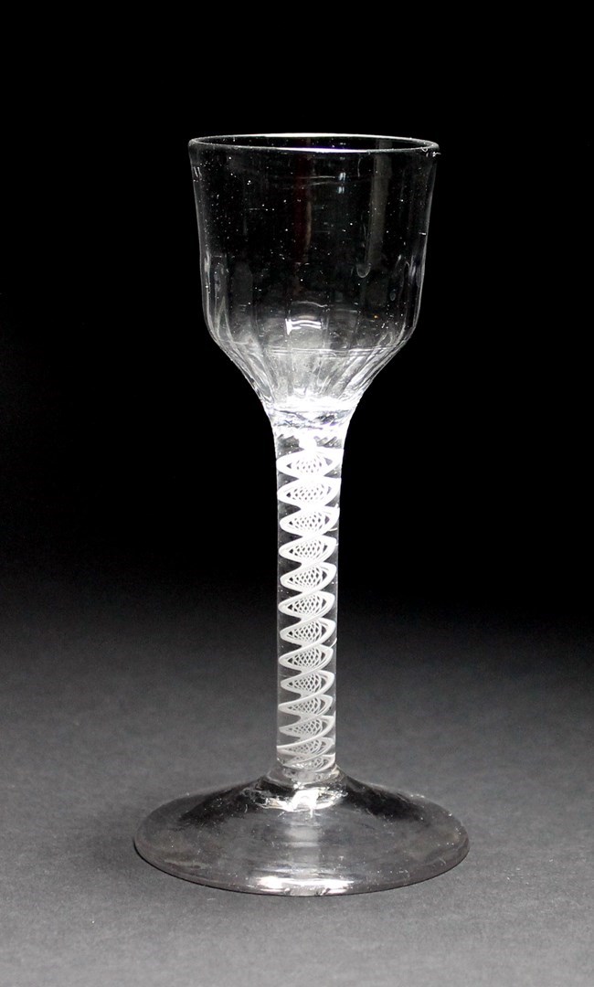 Appraisal: An opaque twist wine glass circa the ogee moulded bowl