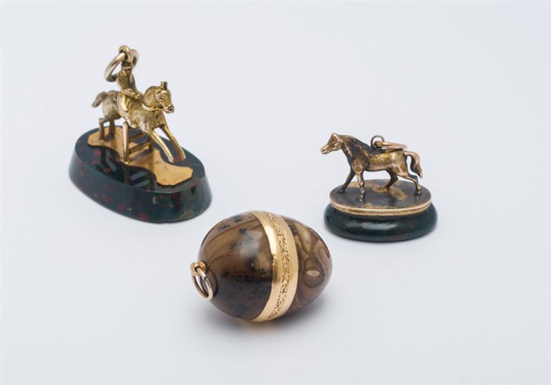 Appraisal: TWO GOLD-MOUNTED HARDSTONE HORSE PENDANTS AND GOLD-MOUNTED EGG-FORM PENDANT Unmarked