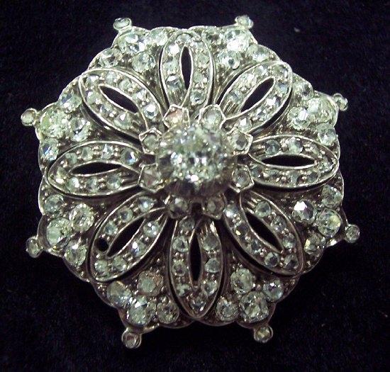 Appraisal: A diamond brooch of flower head form the central stone