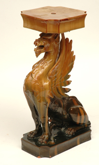 Appraisal: A MAJOLICA GLAZED EARTHENWARE PLINTH MODELLED AS A GRIFFIN cm