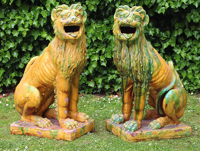 Appraisal: A PAIR OF GREEN AND YELLOW GLAZED TERRACOTTA LIONS seated