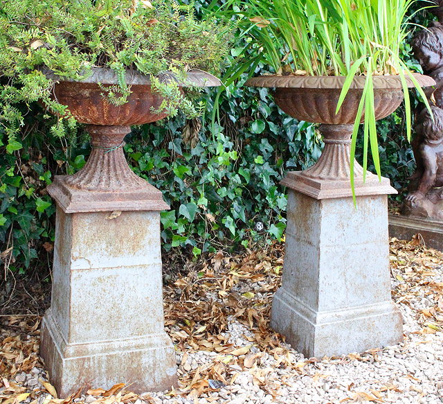 Appraisal: A PAIR OF CAST IRON SHALLOW CAMPANA URNS with egg