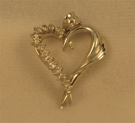 Appraisal: DIAMOND AND FOURTEEN KARAT WHITE GOLD HEART PENDANT one side