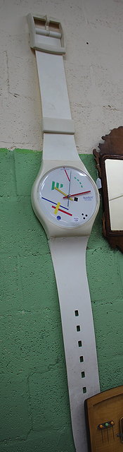 Appraisal: A LARGE WALL HANGING SWATCH WATCH with white plastic strap