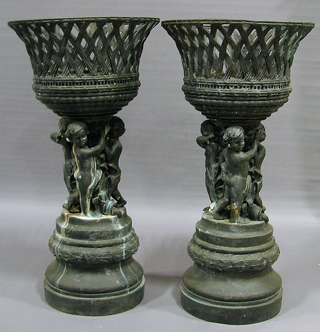 Appraisal: flaring basket form supported by cherubs standing on a drum-form