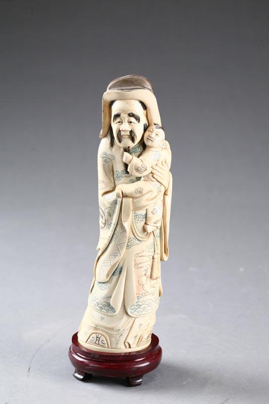 Appraisal: CARVED IVORY FIGURE China Bearded man carrying a child Polychrome