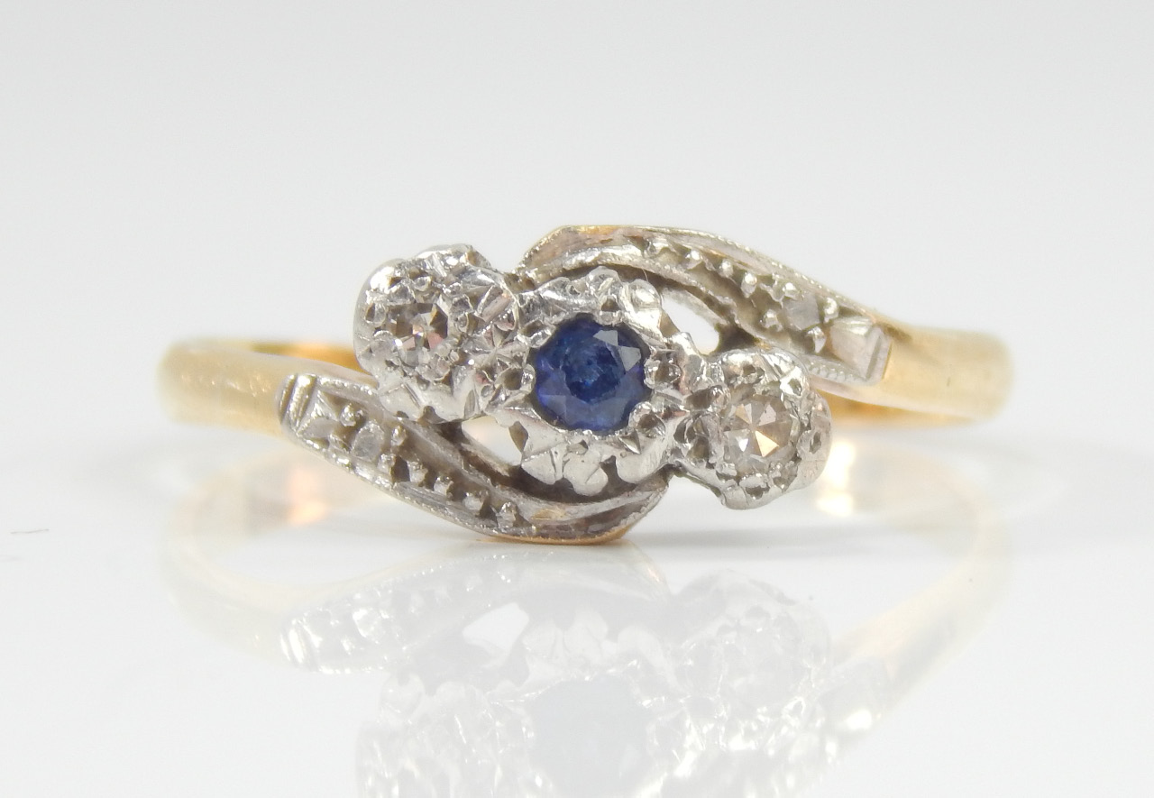 Appraisal: A diamond and sapphire crossover ring with central sapphire stone