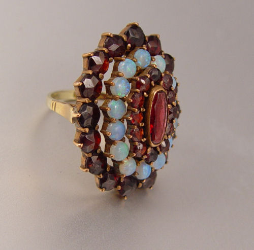 Appraisal: K GARNET AND OPAL RING K yellow gold ring contains