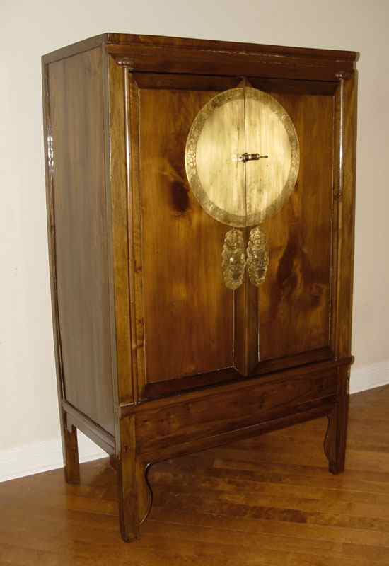 Appraisal: CHINESE WARDROBE CABINET Bold brass medallion on the two doors