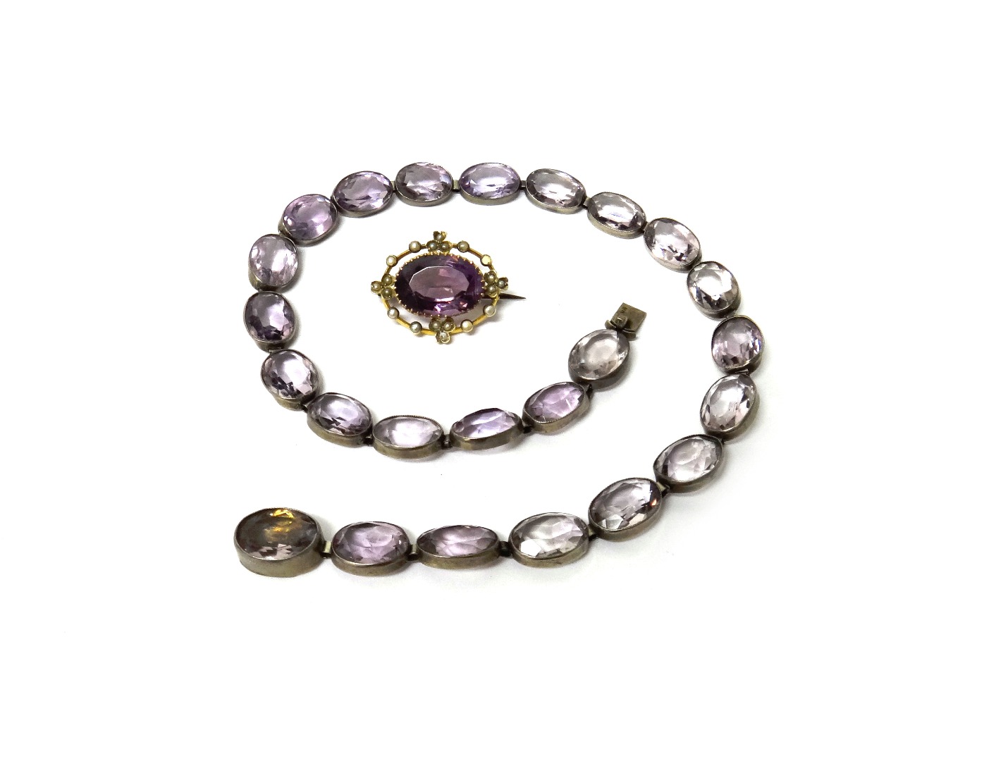 Appraisal: A gold amethyst and seed pearl set oval brooch claw