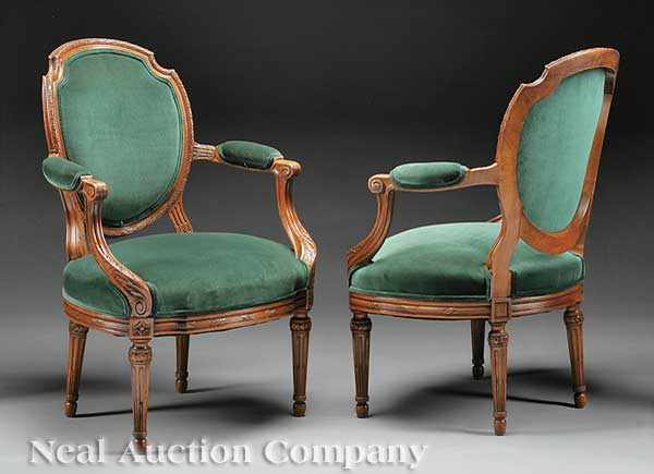 Appraisal: A Pair of Louis XVI-Style Carved Walnut Fauteuils shaped molded