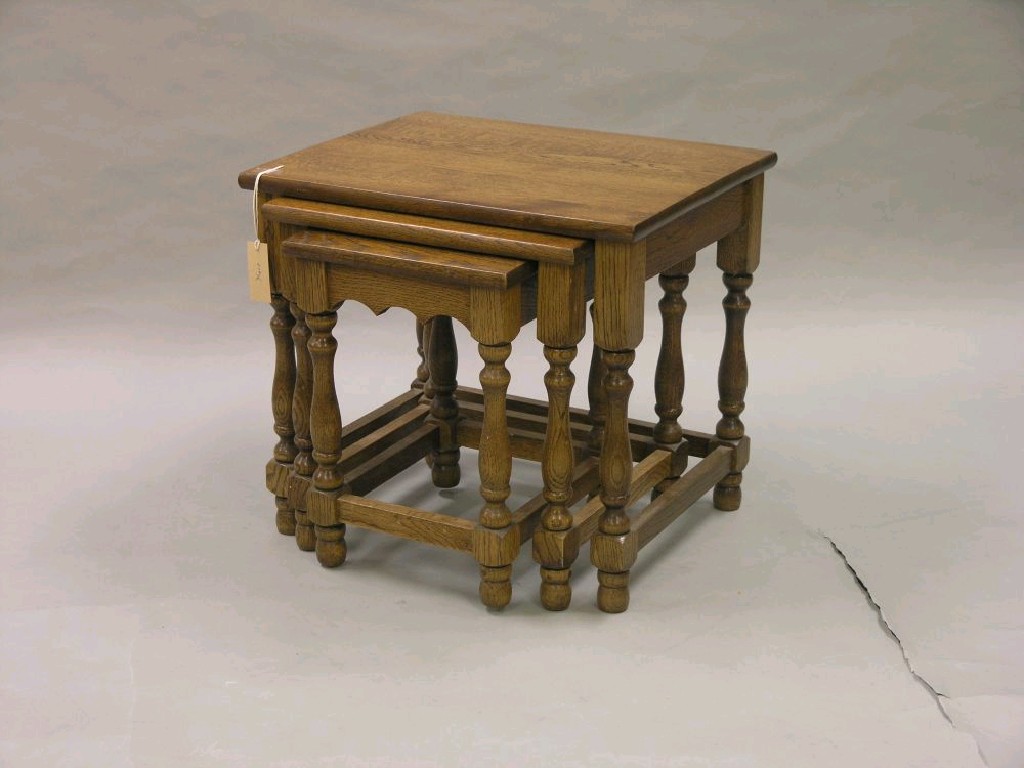 Appraisal: A solid medium oak nest of three tables on baluster