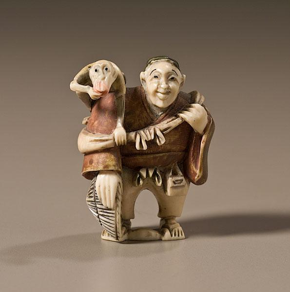 Appraisal: CARVED IVORY NETSUKE OF A MONKEY TRAINER th century of