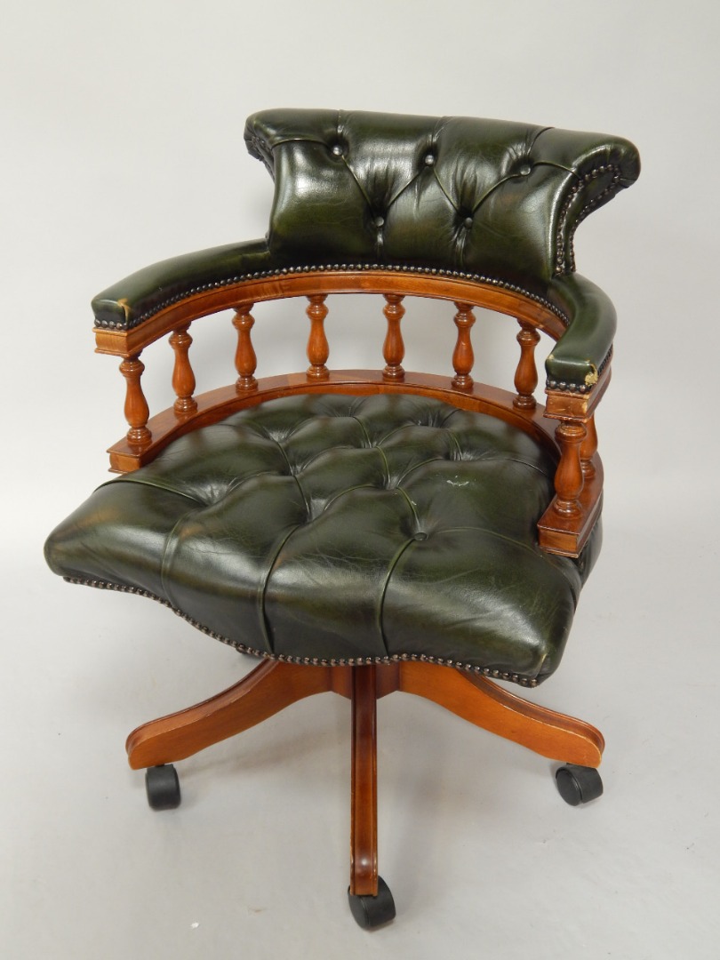 Appraisal: An office swivel chair in green button upholstered hide