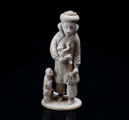 Appraisal: A Chinese carved ivory figure group of a woman with