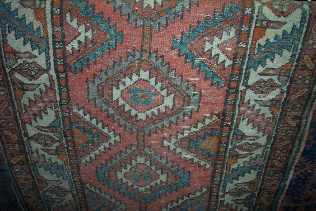 Appraisal: A red ground Eastern wool runner with repeating geometric decoration