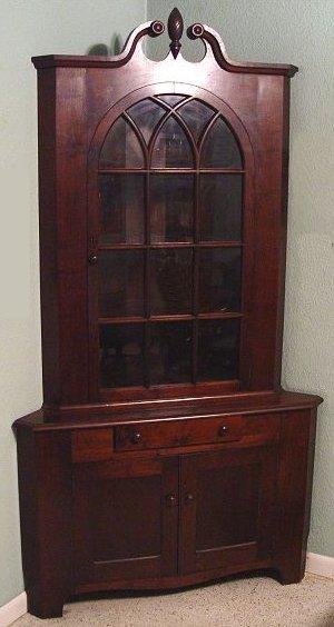 Appraisal: WALNUT CORNER CUPBOARD Arched glass door under traditional broken swan