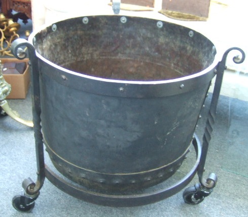 Appraisal: A wrought iron and rivited circular log bin on castors